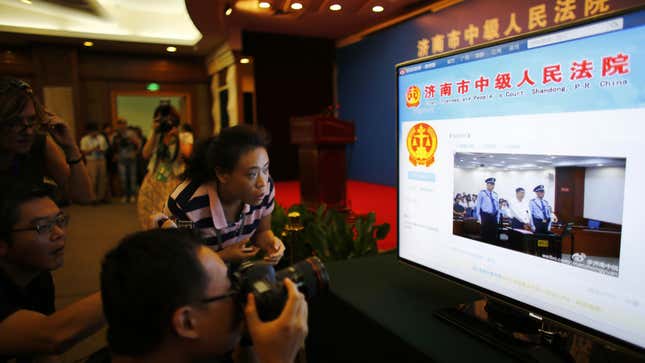 A journalist takes pictures of a screen displaying a court's microblog page showing disgraced Chinese politician Bo Xilai standing trial inside the court, in Jinan, Shandong province August 22, 2013. Bo appeared in public for the first time in more than a year on Thursday to face trial in eastern China, the final chapter of the country's most politically charged case in more than three decades. REUTERS/Carlos Barria