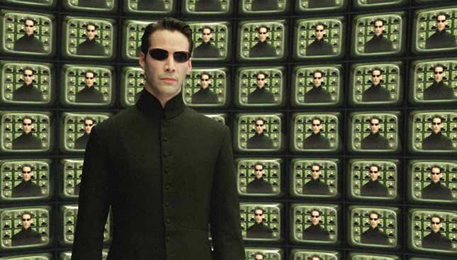 Neo stands in front of TVs with himself on them