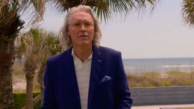 Terry Silver with long hair and blue suit.