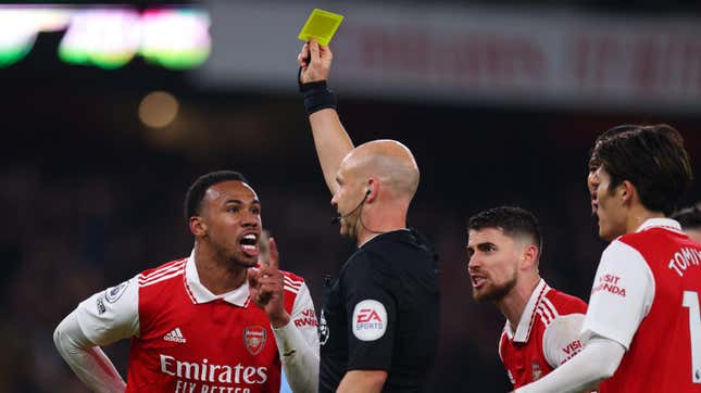 Gabriel Magalhaes and Jorginho of Arsenal confront referee Anthony Taylor during a Feb. 15, 2023, Premier League match between Arsenal FC and Manchester City at Emirates Stadium.