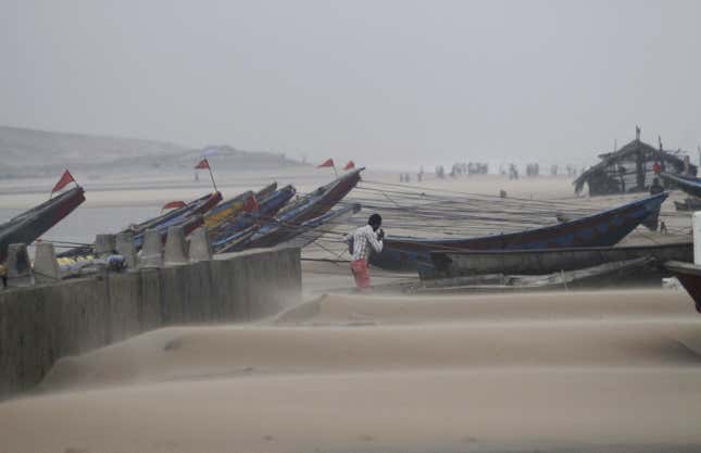 A fisherman walks near the anchored fishing boats in Gopalpur, Orissa, about 285 kilometers (178 miles) north east of Visakhapatnam.