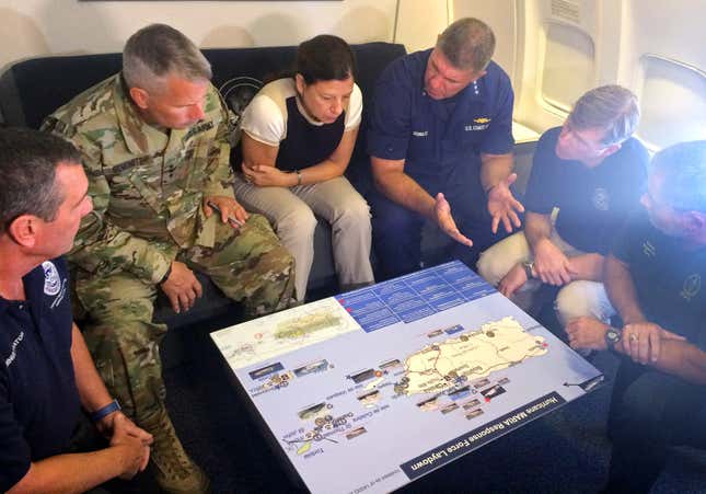 Duke, center, is briefed on the Hurricane Maria response during a flight to Puerto Rico in September.