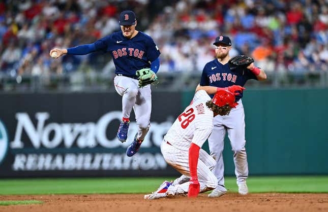 May 6, 2023; Philadelphia, Pennsylvania, USA; Boston Red Sox shortstop Kike Hernandez (5) leaps over Philadelphia Phillies infielder Alec Bohm (28) in the sixth inning at Citizens Bank Park.