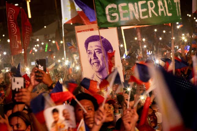 A portrait of Ferdinand "Bongbong" Marcos Jr., the son and namesake of the late Philippine dictator, is seen among the crowd of supporters during the presidential candidate's final campaign rally.