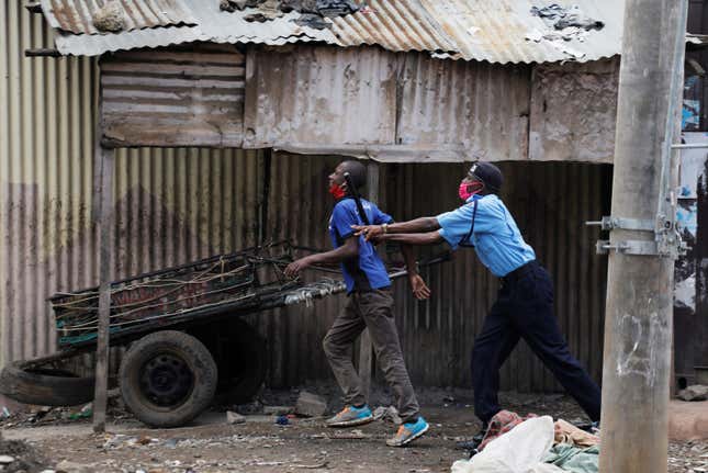 A police officer pushes a man trying to cross a police checkpoint, after the government announced a two weeks lockdown of the neighbourhood of Eastleigh, Nairobi, Kenya May 7, 2020.