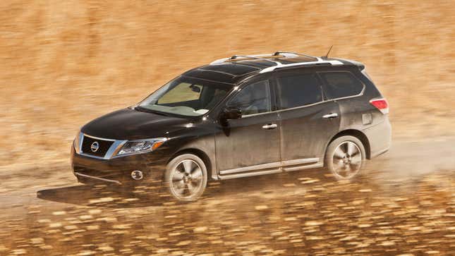 A photo of a black Nissan Pathfinder SUV driving on dirt. 
