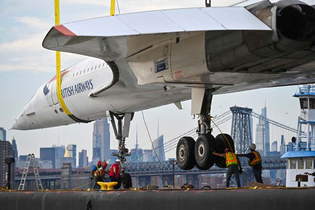 Workers use a large crane to lift a British Airways Concorde at the GMD Shipyard at Brooklyn Navy Yard on August 9, 2023 in New York City.