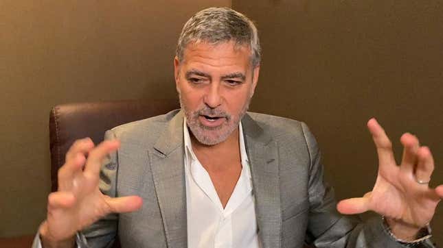 George Clooney mid-sentence, holding hands out in front of him