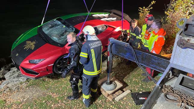 A red, green and black striped Lamborghini is lifted out a lake 