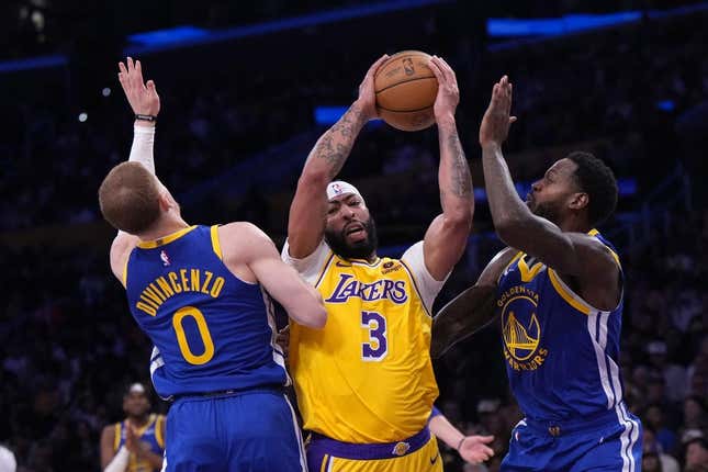 May 8, 2023; Los Angeles, California, USA; Los Angeles Lakers forward Anthony Davis (3) is defended by Golden State Warriors guard Donte DiVincenzo (0) and forward JaMychal Green (1) in the first half during game four of the 2023 NBA playoffs at Crypto.com Arena.