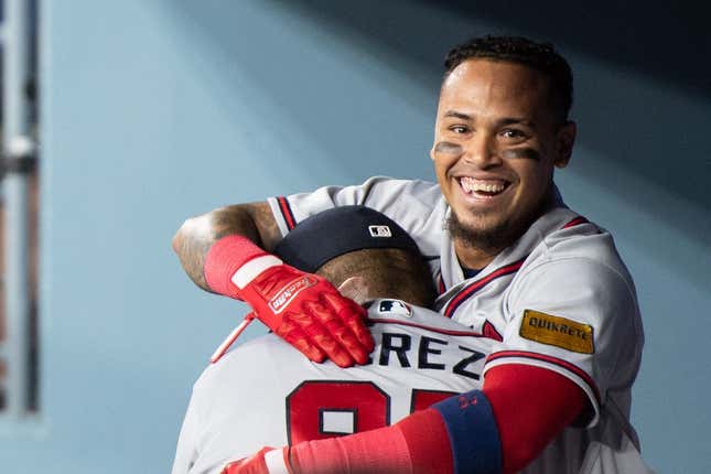 Sep 2, 2023; Los Angeles, California, USA; Atlanta Braves shortstop Orlando Arcia (11) celebrates with major league coach Eddie P rez (95) in the dugout after hitting a triple RBI home run against the Los Angeles Dodgers during the 10th inning at Dodger Stadium.