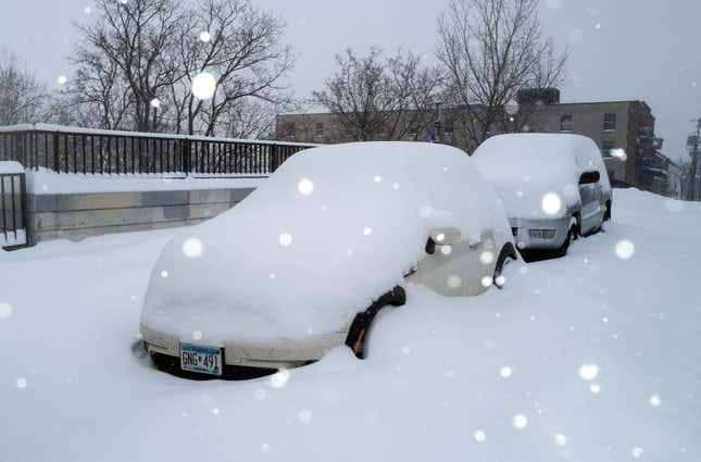 Snow falls as cars sit parked under a blanket of snow on February 23, 2023 in Minneapolis, Minnesota. 