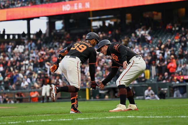 May 6, 2023; San Francisco, California, USA; San Francisco Giants infielder Thairo Estrada (39) shakes hands with third base coach Mark Hallberg (91) after hitting a two-run home run against the Milwaukee Brewers during the third inning at Oracle Park.