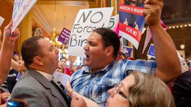 A pastor, left, argues with a Des Moines resident as protesters clashed in the Iowa State Capitol rotunda Tuesday. 