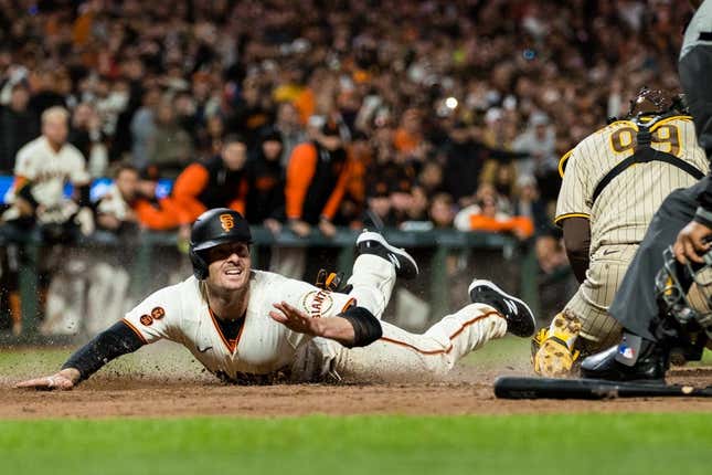 Jun 19, 2023; San Francisco, California, USA; San Francisco Giants right fielder Mike Yastrzemski (5) dives home to score Behring San Diego Padres catcher Gary Sanchez (99) during the ninth inning at Oracle Park.
