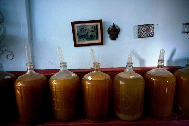 Several condom topped wine jugs stand in winemaker Orestes Estevez’ house. (AP Photo/Ramon Espinosa)