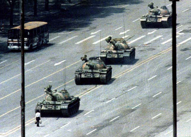 A citizen stands passively in front of a convoy of tanks on the Avenue of Eternal peace