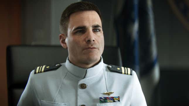 This marine is tting in a chair, staring off-screen at someone in the middle of a conversation.