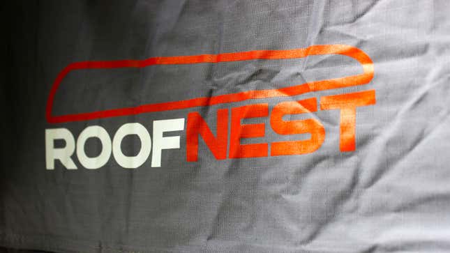 A close up photo of the white and orange Roofnest logo.