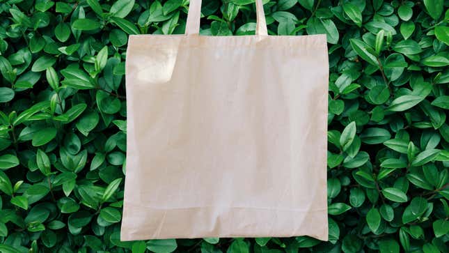 A decorative image of a cotton tote in front of a background of greenery 