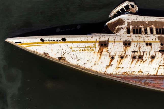 Image for article titled Saddam Hussein's Overturned Yacht is a curious attraction for Iraqi sightseers and locals