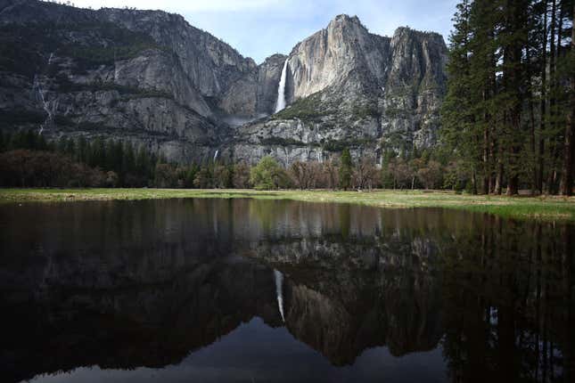 Yosemite Falls, which is fed almost completely by snowmelt, is reflected in a partially flooded meadow as warm temperatures have increased snowpack runoff on April 29, 2023 in Yosemite National Park, California.