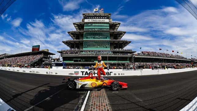 Josef Newgarden of Team Penske celebrates winning the 2023 Indy 500 by parking on the yard of bricks ahead of the Pagoda and running into the crowd