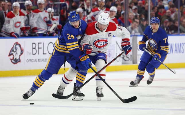 Mar 27, 2023; Buffalo, New York, USA;  Buffalo Sabres center Dylan Cozens (24) and Montreal Canadiens center Nick Suzuki (14) battle for a loose puck during the first period at KeyBank Center.