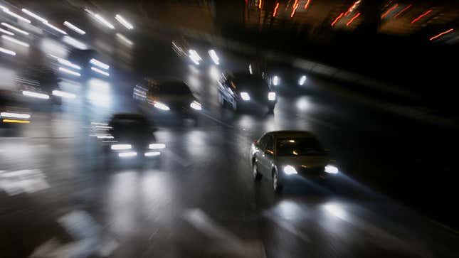 A photo showing car headlamps light up a dark road