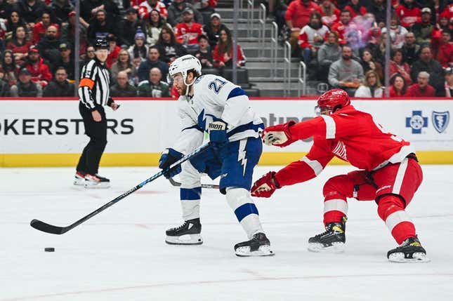 Feb 25, 2023; Detroit, Michigan, USA; Tampa Bay Lightning center Brayden Point (21) brings the puck up ice against Detroit Red Wings defenseman Jake Walman (96) and scores a goal during the first period at Little Caesars Arena.
