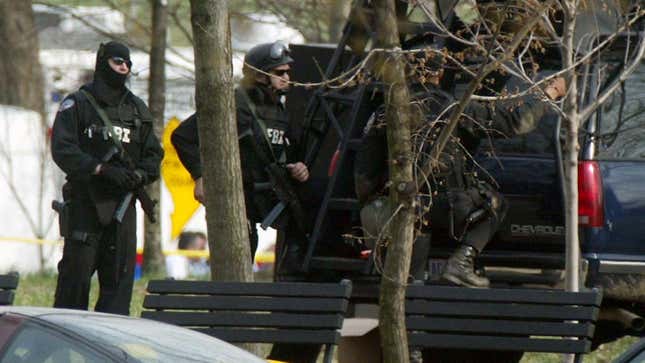 FBI agents with combat gear stand by a vehicle during a standoff with Dwight Watson, a former military policeman of North Carolina, who drove his tractor into a pond at the National Mall March 18, 2003 in Washington, DC