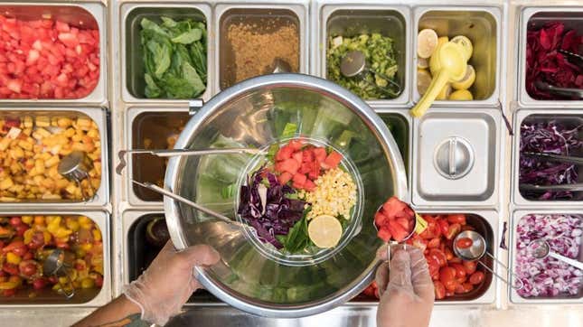 Overhead view of the Sweetgreen salad station full of toppings 