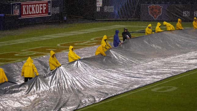 Workers remove a tarp from the turf at Soldier Field before an NFL football game between the Chicago Bears and the San Francisco 49ers Sunday, Sept. 11, 2022, in Chicago.