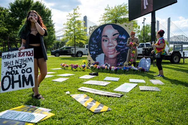 Protesters and volunteers prepare a Breonna Taylor art installation by laying posters and flowers before the “Praise in the Park” event at the Big Four Lawn on June 5, 2021 in Louisville, Kentucky.