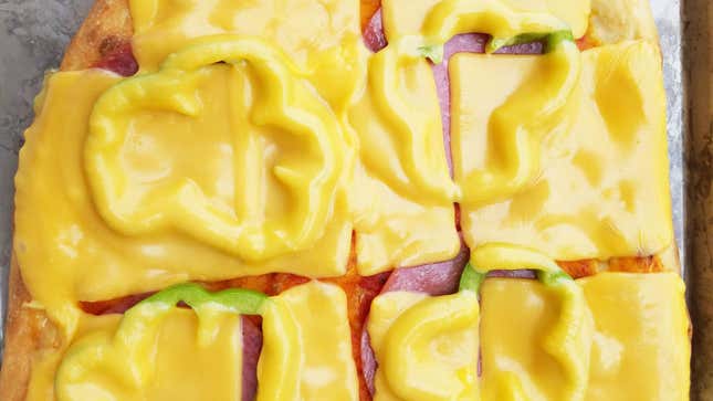 Overhead view of pizza covered in glossy melted slices of American cheese