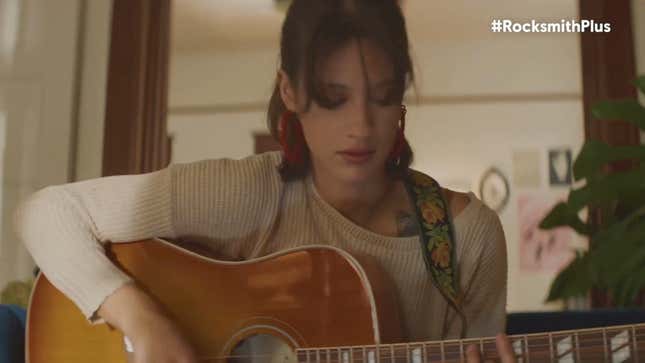 A woman plays an acoustic guitar.