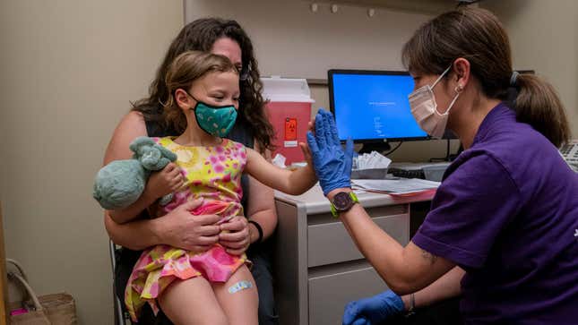 A 3-year-old sits on the lap of her mother and  gets a high five from a nurse after receiving her first dose  of the Pfizer covid-19 vaccination at UW Medical Center on June 21, 2022 in Seattle, Washington.