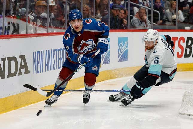 Apr 20, 2023; Denver, Colorado, USA; Colorado Avalanche center Evan Rodrigues (9) controls the puck ahead of Seattle Kraken defenseman Adam Larsson (6) in the second period in game two of the first round of the 2023 Stanley Cup Playoffs at Ball Arena.