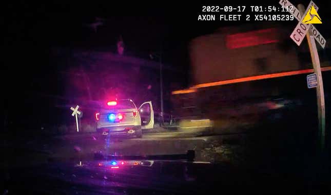 This screen grab from dash camera video provided by the Fort Lupton Police Department shows a freight train barreling toward a parked police car with a suspect inside, Sept. 16, 2022, in Fort Lupton, Colo. A trial began Monday, July 24, 2023, for the police officer accused of putting the handcuffed woman in the car that was hit by the train. The collision seriously injured 21-year-old Yareni Rios. The date/time stamp shown on the video is incorrect. 