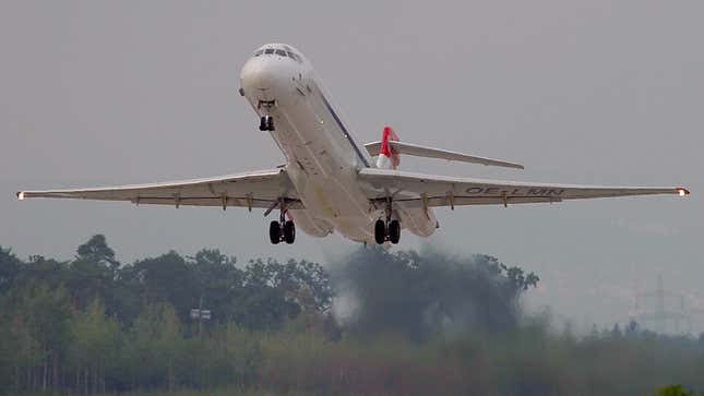 A McDonnell Douglas MD-87 plane takes off from a runway. 