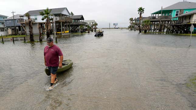 Bubba Ferguson schleppt nach dem Hurrikan Nicholas im September ein Boot durch eine überflutete Straße.  14. Februar 2021, in San Luis Pass, Texas.