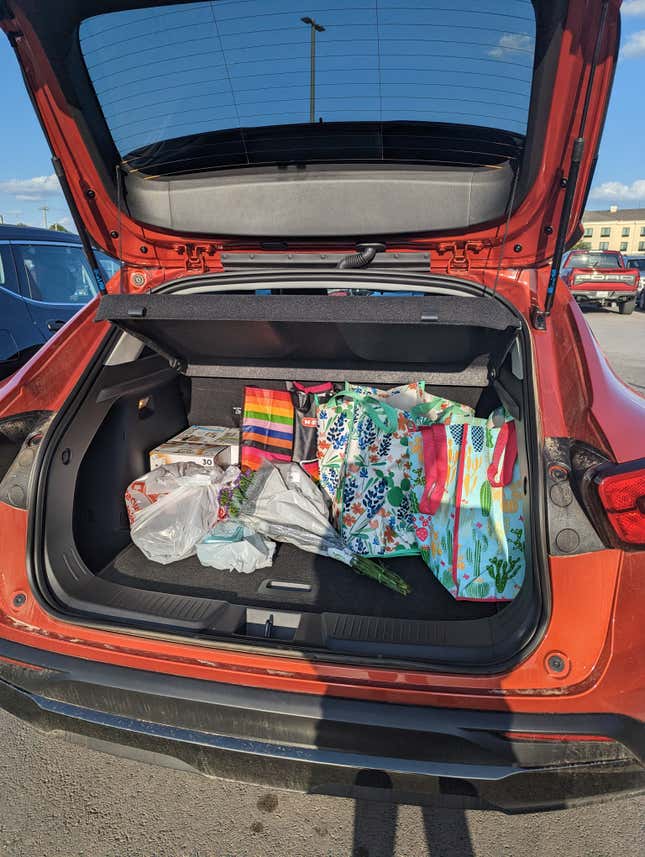 The trunk of the 2024 Chevy Trax filled with five bags of groceries, two boxes of Fancy Feast cat food, and a bouquet of flowers