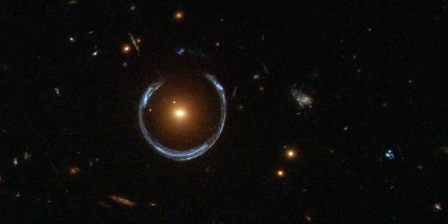 An Einstein ring encircles a luminous red galaxy, a glaring example of gravitational lensing.