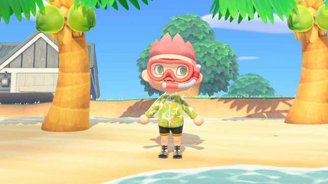A young man wearing a snorkel with pink hair stands on a beach.