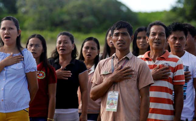 Filipinos living in Philippine occupied (Pagasa) Thitu island, in disputed South China Sea, sing the country's national anthem April 21, 2017.