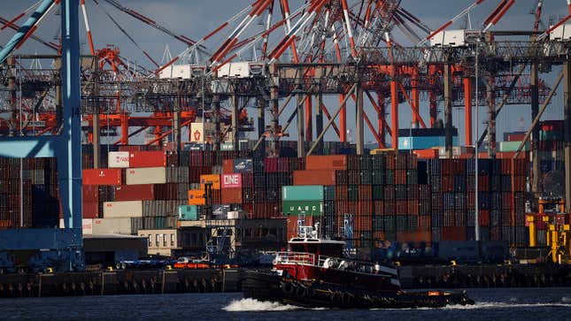 Shipping containers are shown stacked up at a port.