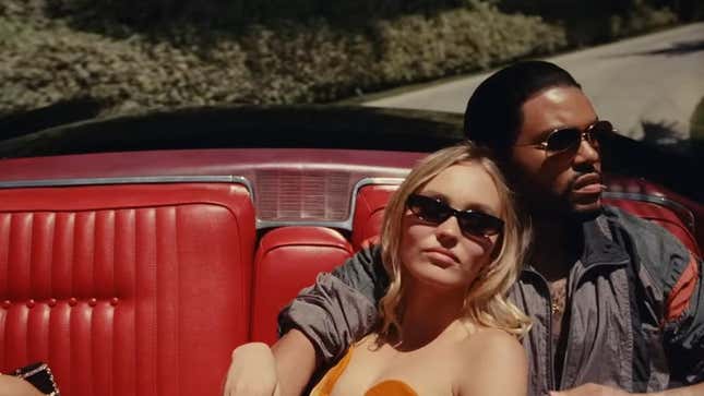 A screenshot from The Idol of The Weeknd and Lily-Rose Depp rising in a red convertible with the top down