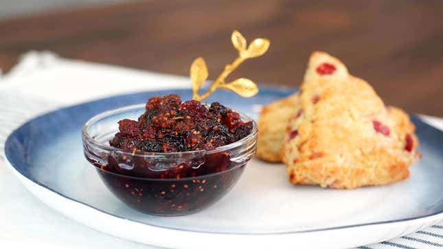 Homemade Mulberry Jam in a small bowl on a plate with two raspberry scones