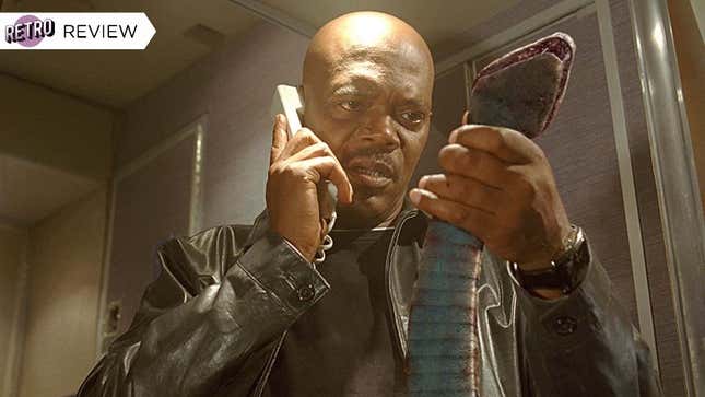 Samuel L. Jackson wears a leather jacket and black t-shirt while holding a corded phone in one hand and a large snake in the other in Snakes on a Plane.