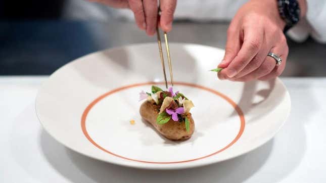 Chef's hands arranging delicately plated entree